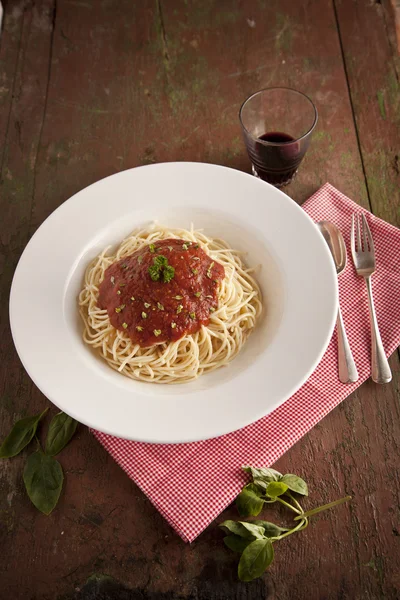 Spaghetti met tomaten saus en basilicum diner close-up — Stockfoto