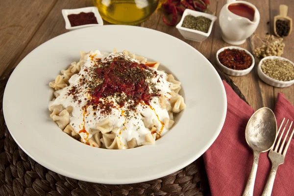 Manlama turco Manti em prato com pimenta vermelha, molho de tomate, iogurte e hortelã — Fotografia de Stock