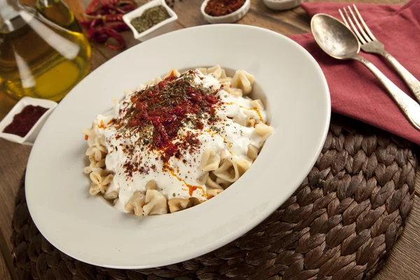 Manlama turco Manti em prato com pimenta vermelha, molho de tomate, iogurte e hortelã — Fotografia de Stock