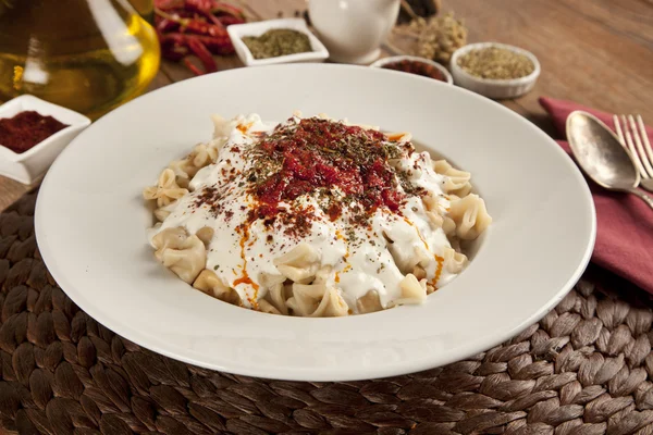 Manlama turco Manti su piatto con peperoncino, salsa di pomodori, yogurt e menta — Foto Stock