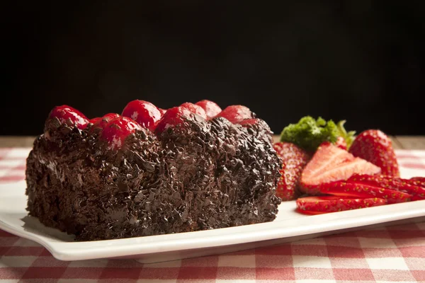 Pedazo de pastel de chocolate con glaseado y baya fresca — Foto de Stock