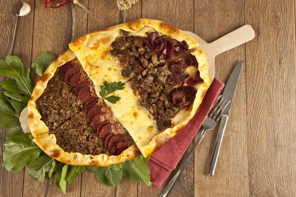 Hausgemachte traditionelle türkische Mahlzeit Pizza Pide gefüllt mit Fleisch, Käse, Pastirma und Wurst — Stockfoto