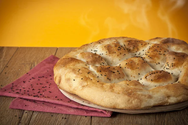 トルコのラマダン パン - ラマザン Pidesi 黄色の背景の木のテーブルの上 — ストック写真