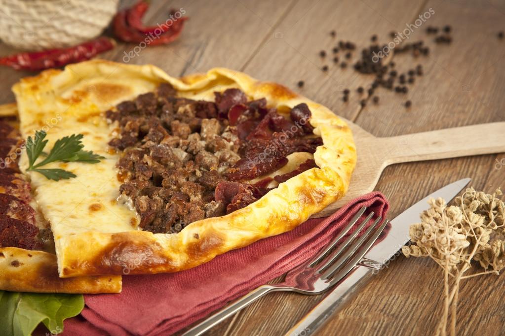 Homemade traditional Turkish meal pizza pide stuffed with meat, cheese