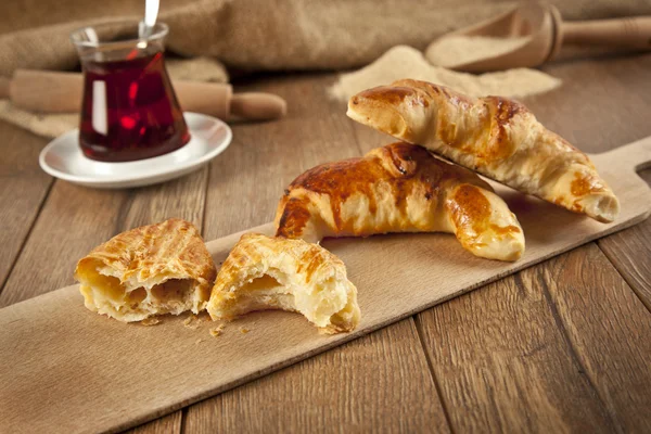 Typical turkish owen product cheese pogaca with wood plate and black tea — Stock Photo, Image