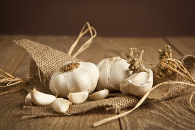 Bütün organik sarımsak ve ahşap arka planda karanfil.