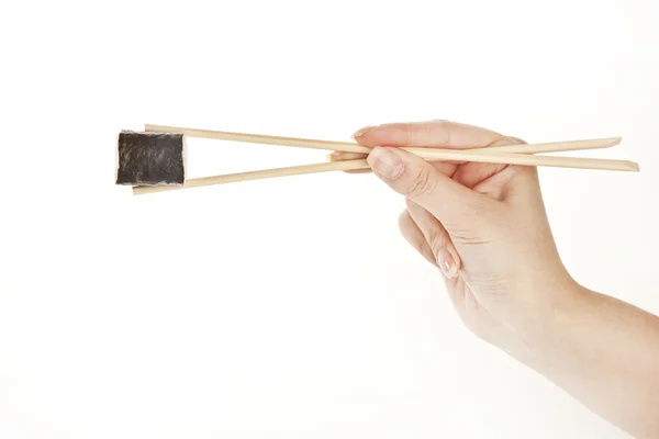 Mão segurando rolo de sushi com pauzinhos, isolado em branco — Fotografia de Stock