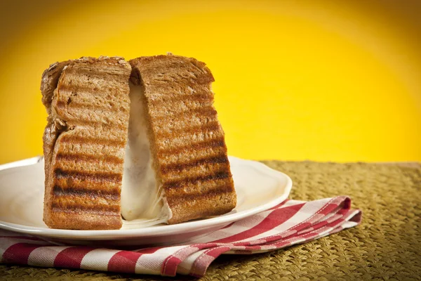 Toasted cheese sandwich with melting cheese oozing out. — Stock Photo, Image