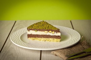 Fıstıklı cheesecake, kremalı pasta, fındıklı beyaz tabak.