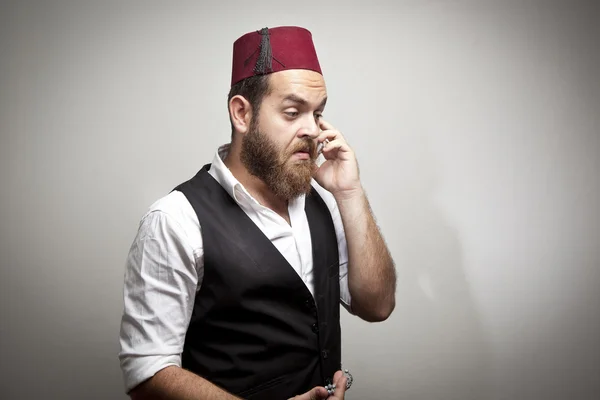 Мужчина в традиционной турецкой шляпе и платье кабадайи говорящий телефон — стоковое фото