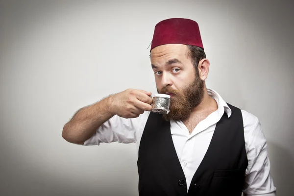 Человек в традиционной турецкой шляпе и платье kabadayi пить турецкий кофе — стоковое фото