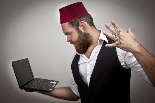 Man in traditional turkish hat and dress kabadayi with laptop — Stock Photo, Image