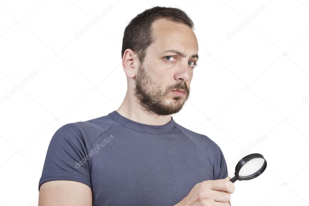 Astonished man looking through a magnifying glass