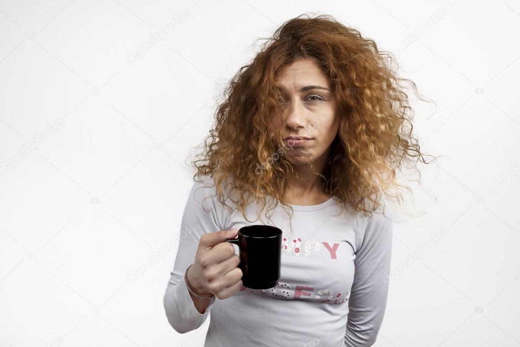 Tired sleepy woman waking up with cup of coffee