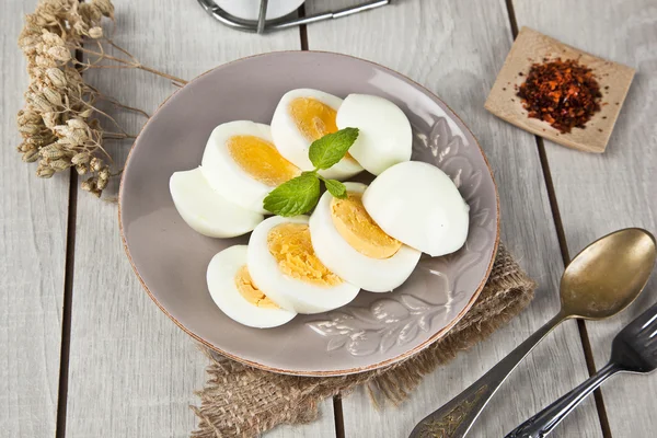 Kokta ägg med mynta blad och vita träbord — Stockfoto