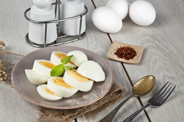 Œufs durs avec feuille de menthe et table en bois blanc — Photo