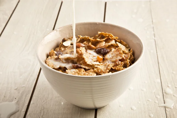 Bowl of sugar-coated corn flakes and spoon wooden background — Stock Photo, Image