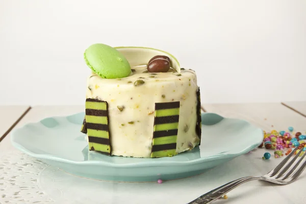 Bolo de queijo Pistachio, bolo de mousse com decoração de chocolate em uma placa branca — Fotografia de Stock