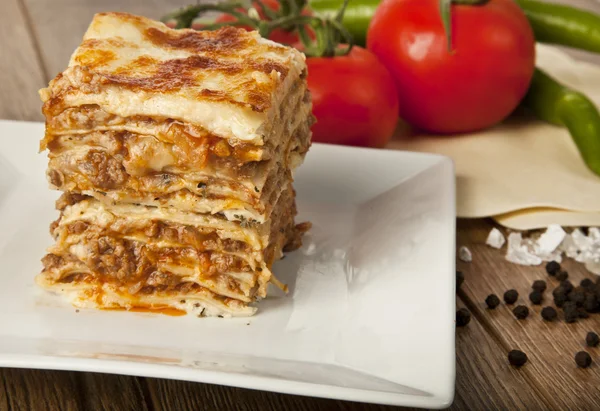 Een stuk van Italiaanse lasagne Bolonese op een vierkante plaat — Stockfoto