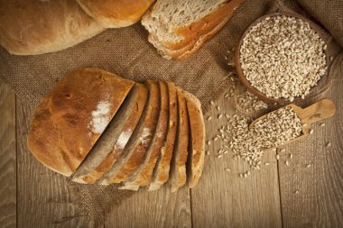 Kepekli ekmek, buğday tohumu ve ahşap arka plan ile ekmek dilimleri