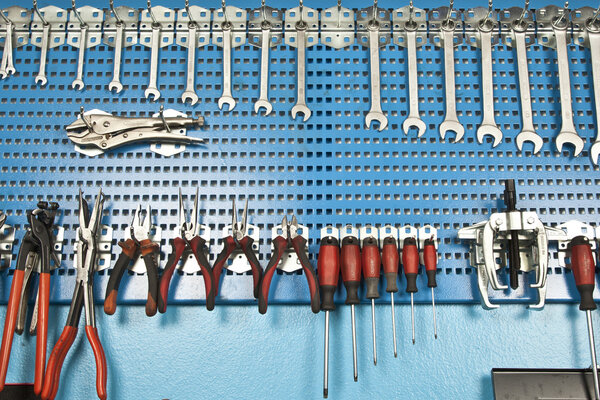 Различные инструменты для ремонта автомобилей, установленные на стене
