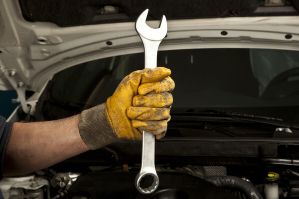 Auto mechanic working in garage. Repair service.