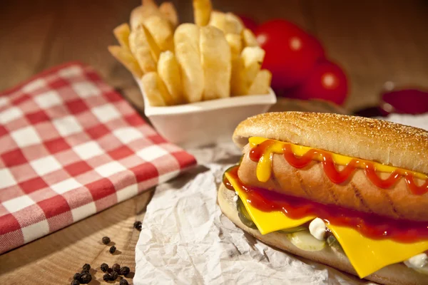 Hot Dog com batatas fritas e queijo cheddar conceito fundo — Fotografia de Stock