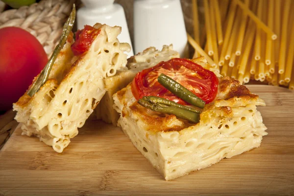 Сыр макароны все еще кипит ломтиками из духовки. на деревянном фоне — стоковое фото