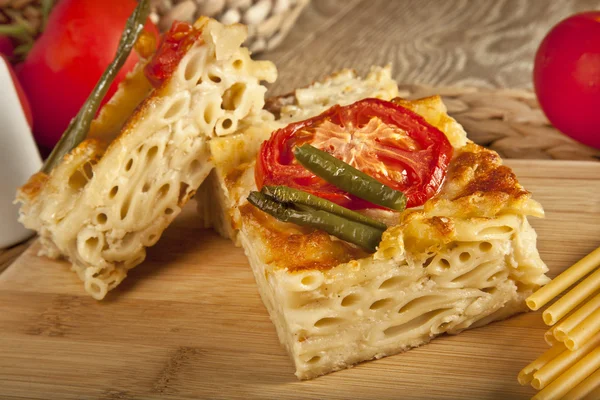 マカロニ チーズはまだオーブンからバブルのスライスです。木製の背景を持つ — ストック写真