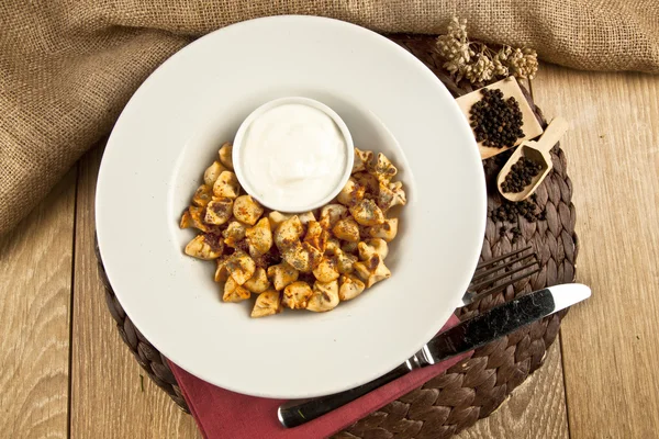 Turkish Fried Manti manlama on plate with red pepper, tomatoes sauce, yogurt and mint — Stock Photo, Image