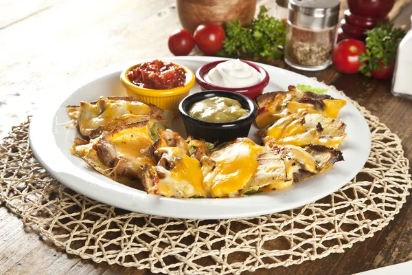 Nachos con salsa de guacemole y queso cheddar — Foto de Stock