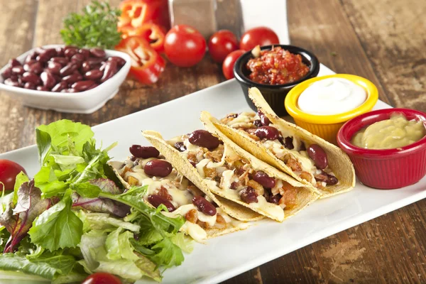 Bir tabak lezzetli tacos limon, domates, marul ve peynir ile. — Stok fotoğraf