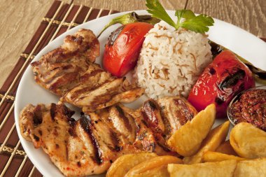 Izgara tavuk ve pilav pilav ve patates ahşap arka plan üzerinde