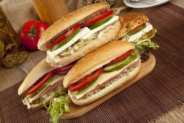 Panini sottomarini con prosciutto e formaggio da baguette fresche . — Foto Stock