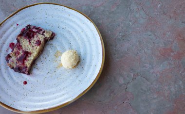 Kırmızı meyveler ufalıyor ve küçük bir vanilyalı dondurma topu tatlısı mermer pembe bir masada yemeye hazır. Boşluğu sağ tarafa kopyala.