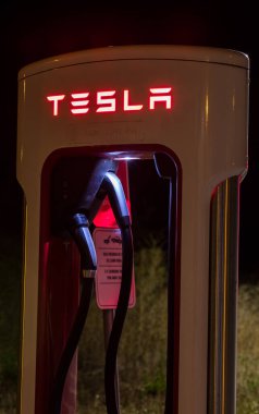 Ponferrada kenar mahalleleri, İspanya - 09 Ağustos 2021: Tesla süperşarj istasyonu, gece. Tesla bir Amerikan elektrikli aracı ve temiz enerji şirketi.