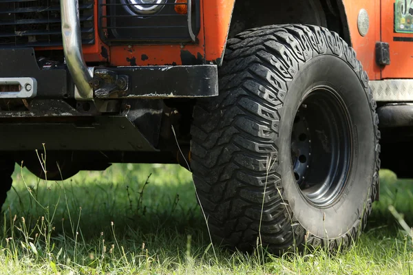 Grote jeep wiel op een gras — Stockfoto