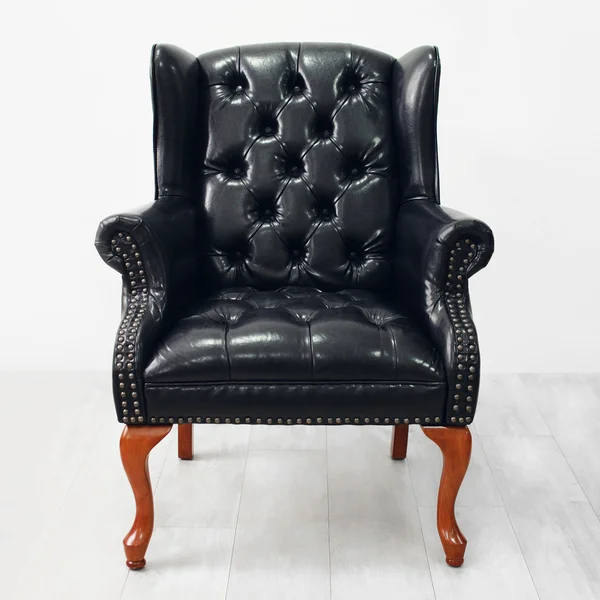 Luksusowy czarny skórzany fotel na białe drewniane podłogi — Zdjęcie stockowe