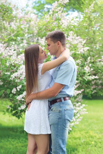 Beautiful young loving couple hugging in blooming spring garden — Stock Photo, Image