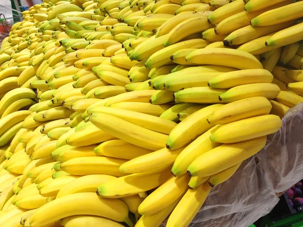 Muitas bananas frescas deitadas em caixas no supermercado — Fotografia de Stock