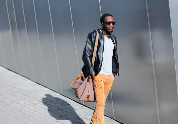 Mode Afrikaanse man loopt in de stad 's avonds over stedelijke achtergrond — Stockfoto