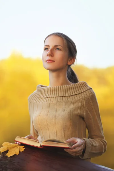 Portret jonge vrouw met boek en geel esdoornblad dromen outd — Stockfoto