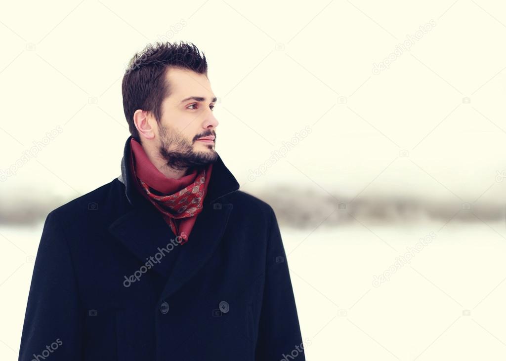 Fashion portrait of handsome bearded brunette man outdoors weari