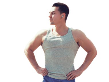 Kulaklıklı bir sporcu portresi. Müzik dinliyor. Beyaz arka planda izole edilmiş fitness erkek modeli.