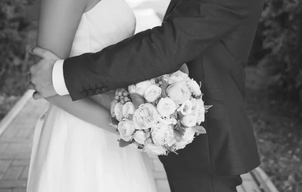 結婚式のカップル 花嫁と新郎 花の花束を閉じ 男は屋外で彼女の恋人の女性を抱きしめる — ストック写真