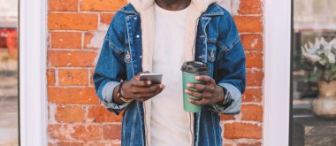 Şehir caddesinde akıllı telefonlu Afrikalı bir adama yakın durun.