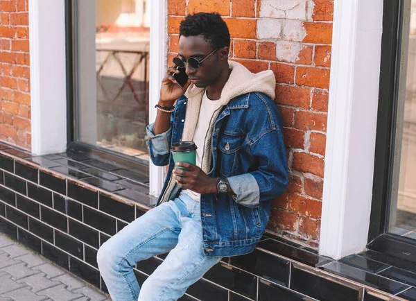 Retrato Joven Africano Hablando Smartphone Mientras Sienta Con Una Taza —  Fotos de Stock