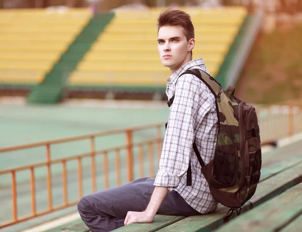 Handsome young pensive man with backpack, modern hipster sitting — Stock Photo, Image