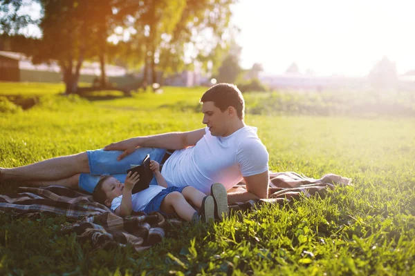 Happy family, dad and son resting in the evening at sunset in th — Stock Photo, Image