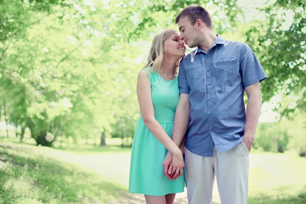 Krásná nabídka mladý pár v lásce chůze v slunečné jaro park, — Stock fotografie